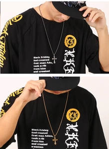 Close-up of gold and silver cross pendants on chains worn by a model in a lifestyle setting
