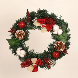 Detail of Christmas wreath with red bow, pine cones, cotton pods, and green pine needles
