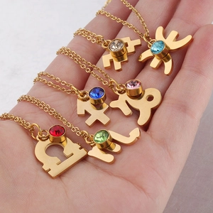 Gold zodiac necklaces with colorful birthstones pendants shown in a hand