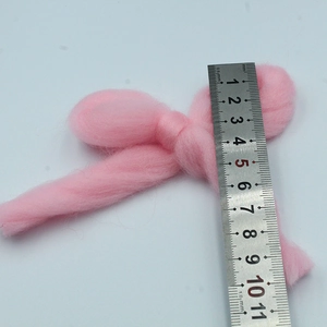 Detail of 11cm pink felt bow Christmas ornament being measured with a steel ruler