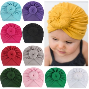 Detail of multi-color velvet baby donut turban hats with soft texture and knotted design