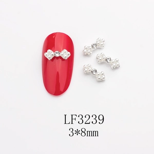Détail macro de nœud décoratif pour ongles en alliage avec perles et strass 3x8mm