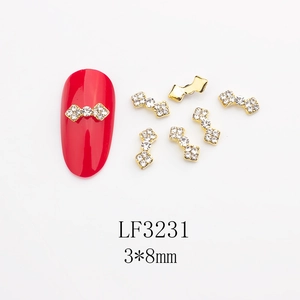 Vue macro de breloque nœud 3x8mm en alliage doré avec perles pour nail art DIY