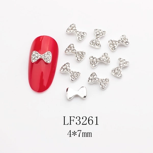 Vue macro de bijou ongle nœud en alliage avec strass et dimensions 4x7mm