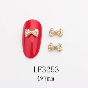 Détail du nœud en alliage 4x7mm avec perles et cristaux sur ongle mannequin rouge