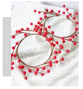 Detail of red artificial berry Christmas wreaths on white faux fur background decoration