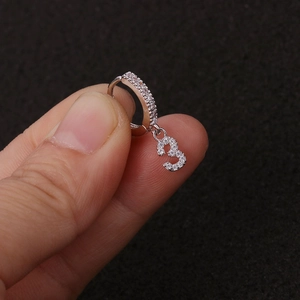Makroaufnahme von Silberohrring mit Zirkonia-Reif und Anhänger in Form der Zahl 3