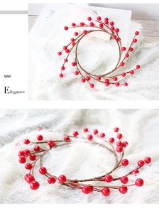 Macro detail of artificial Christmas red berry wreath on white plush background