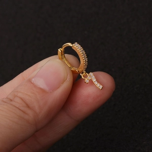 Nahaufnahme einer Gold-Creole mit Nummer 7 Anhänger und glitzernden Zirkonia-Steinen