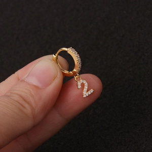 Goldener Ohrring mit Nummer 2 Anhänger und Zirkonia-Steinen auf dunklem Hintergrund