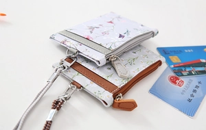 Detail view of double floral card pouches with zippers and a detachable neck lanyard