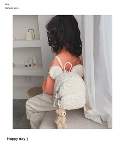 Détail du sac à dos blanc en peluche de laine d'agneau avec pendentif ours mignon