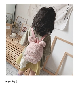 Détail d'un sac à dos enfant en polaire rose avec oreilles de lapin et petit ours