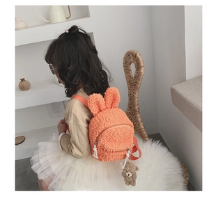 Détail d'un sac à dos en laine d'agneau orange pour enfant avec oreilles de lapin et ours