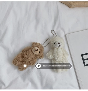 Détail de porte-clés ours en peluche marron et blanc cassé avec chaînes en métal