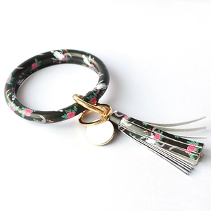 Detail view of black PU leather keychain bracelet with skull rose pattern and gold ring