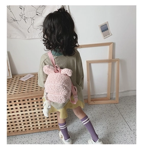 Détail de texture du sac à dos en laine d'agneau rose avec oreilles de lapin et ourson