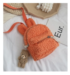 Détail du sac à dos en peluche orange pour enfant avec oreilles de lapin et petit ours
