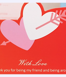 Vue macro d'une carte de vœux en forme de cœur avec texte With Love et flèche