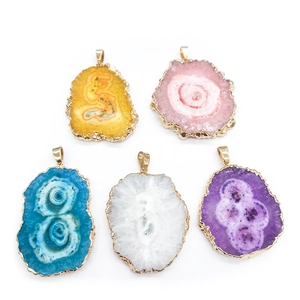 Detail of five natural agate slice sun flower pendants with gold plated edges and textures