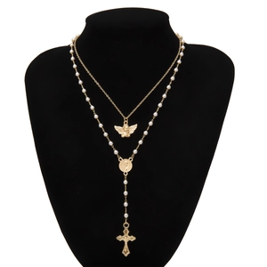 Detail of double-layer gold necklace with angel pendant, pearls and cross tassel