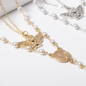 Retro angel pearl Y-necklace with cross tassel in gold and silver finish on white background