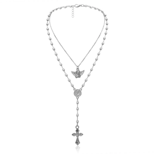 Close-up of silver layered necklace with angel pendant and cross tassel on white base