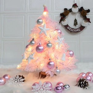 Pink mini Christmas tree with feather accents, silver ornaments, and warm LED lights