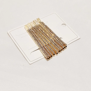 Detail view of 7-piece set gold alloy hair clips with pave crystals on white card