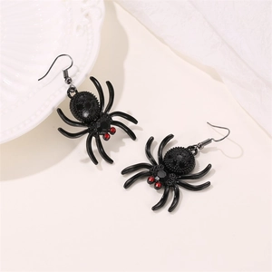 Gothic black spider earrings with red rhinestone eyes and fishhook dangles on a tray