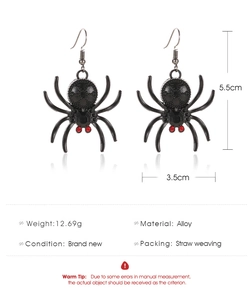 Macro view of black gothic spider earrings with red rhinestone eyes and alloy texture