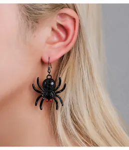 Detail of gothic spider earrings with red rhinestone eyes worn on model for Halloween