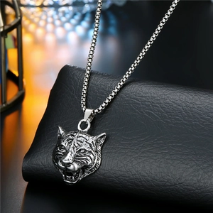 Detailed close-up of a silver tiger head pendant on a stainless steel box chain necklace