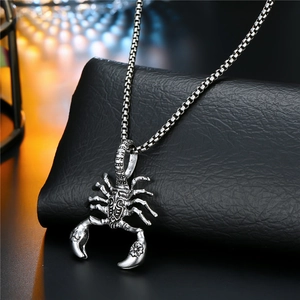 Detail of vintage silver scorpion pendant with textured finish on a box chain for men