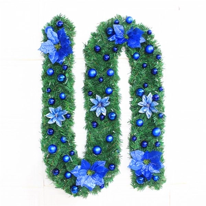 Close-up of a 2.7m lush green Christmas garland with blue ornaments and poinsettia flowers