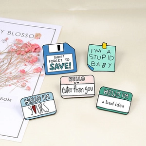 Detailed view of five creative enamel pins with a disk and memo design on a white surface