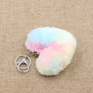 Rainbow gradient heart-shaped plush keychain with metal clasp on beige burlap background