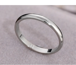Detailed top view of a polished silver stainless steel plain band on purple velvet