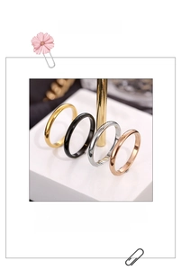 Minimalist stainless steel rings in gold, silver, black, and rose gold on marble
