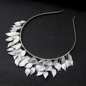 Elegant silver metallic leaf headband with intricate textures on black background