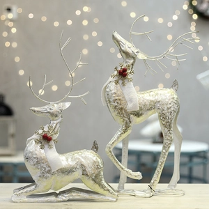 Sparkling silver wire Christmas deer set with white scarf and berry details on warm light