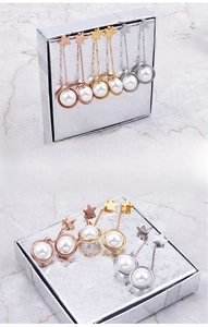 Detailed view of star pearl tassel earrings in rose gold, gold and silver finishes