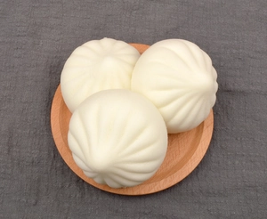 Detailed top view of three realistic soft steamed bun food models on a wooden tray