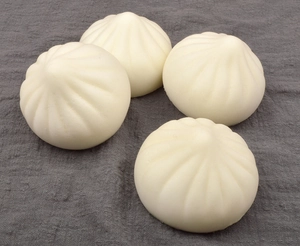 Realistic 7cm steamed bun squeeze toys with detailed texture on grey fabric