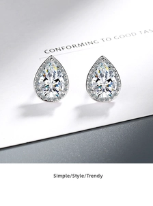 Macro view of pear-cut zircon stud earrings with halo-set diamonds in silver finish
