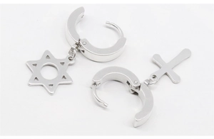 Detail of silver stainless steel hoop earrings with star and cross charms on white background