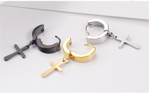 Detailed macro view of titanium steel hoop earrings with cross pendants in black, gold and silver