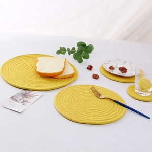 Macro detail of yellow woven cotton rope placemats with minimalist dining props