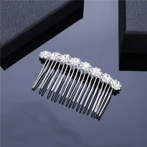 Close-up of silver bridal hair comb with crystal flowers and pearls on dark background