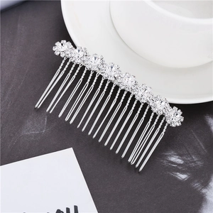 Detailed view of bridal hair comb with silver flowers and crystals on dark texture